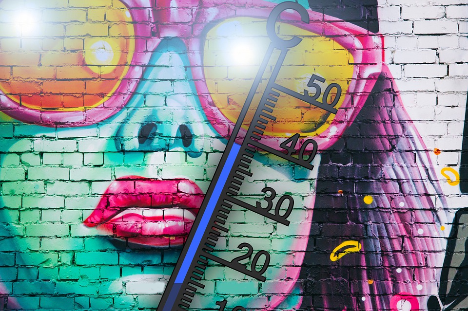 Bild på termometer på graffittimålad tegelvägg