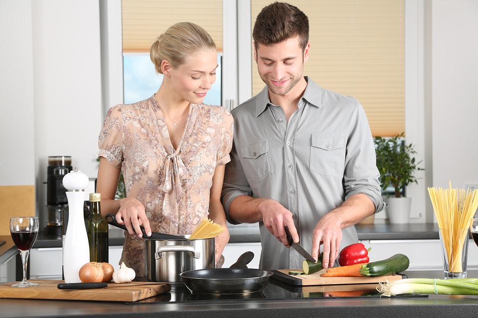 Bild på en kvinna och en man som lagar mat tillsammans